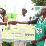 Edo Governor Adams Oshiomhole presents a cheque to Yusuf Biwott, 3rd prize winner with time of 29 mins 50 seconds at the Okpekpe Road Race 10km.