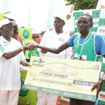 Edo Governor Adams Oshiomhole presents a cheque to Kenyan Moses Masai, Winner with time of 29 mins & 39 seconds at the Okpekpe Road Race 10km.